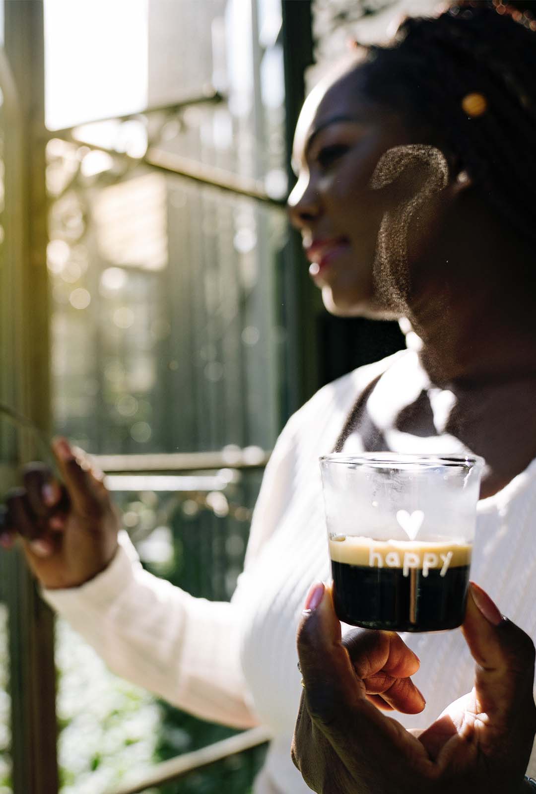 una chica bebiendo un café con un vaso que pone happy