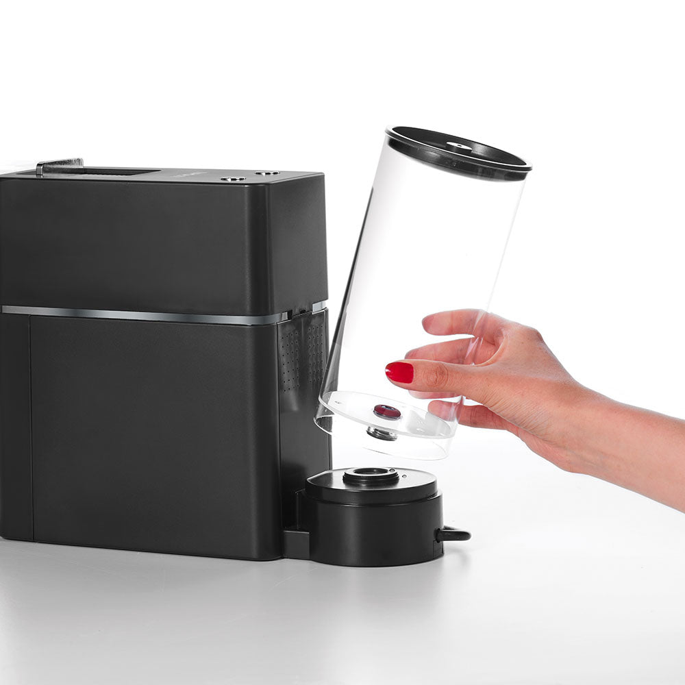 Mano cambiando el depósito de agua de una máquina de café